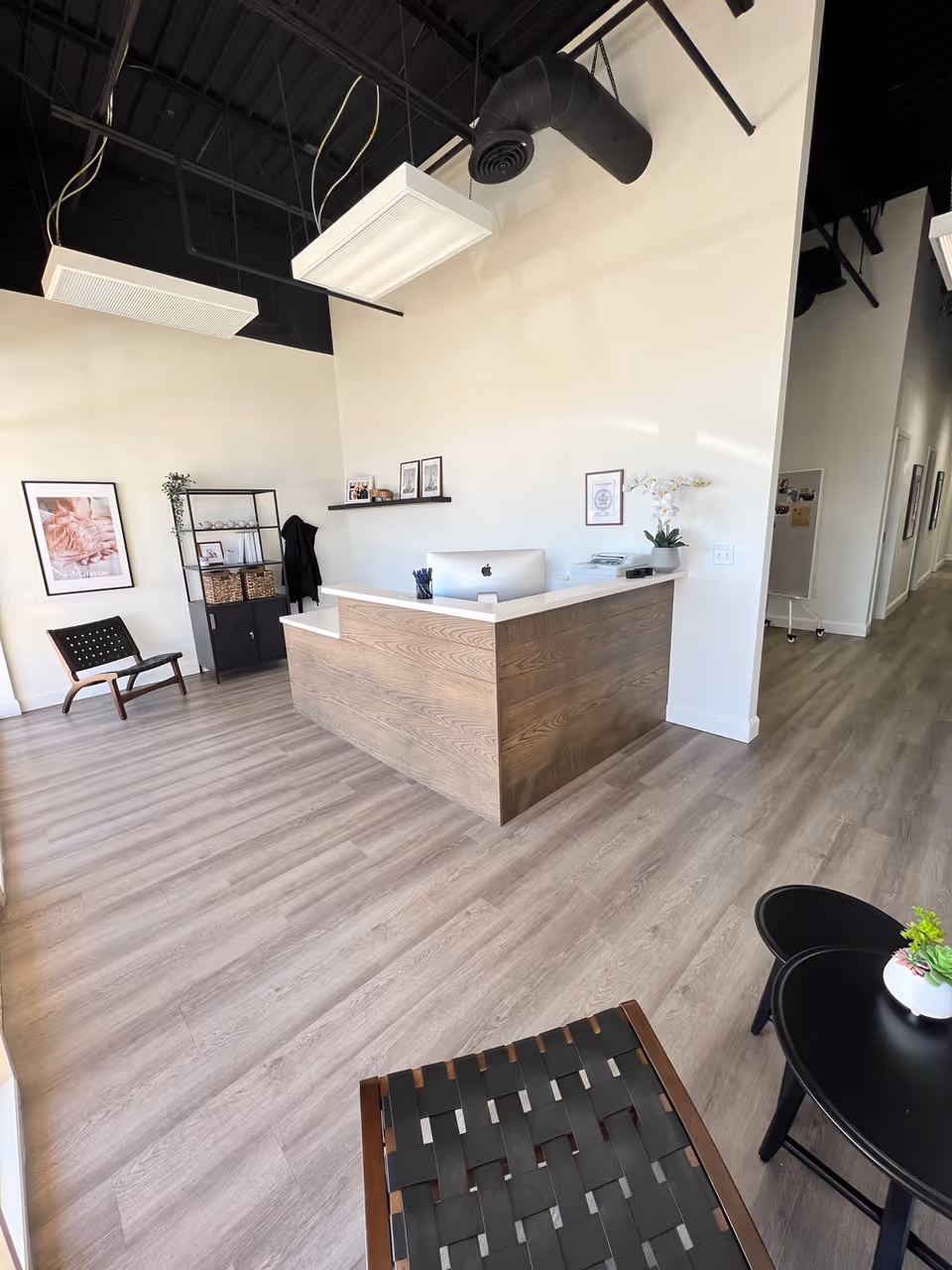 Bright, modern reception area featuring a wooden front desk and seating.