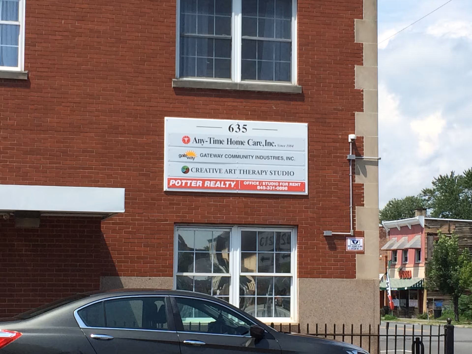Brick building exterior with a sign reading 635 Any-Time Home Care, Inc.