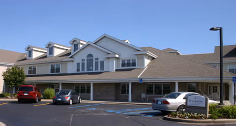 Brookdale Utica senior living facility exterior with parked cars in front.