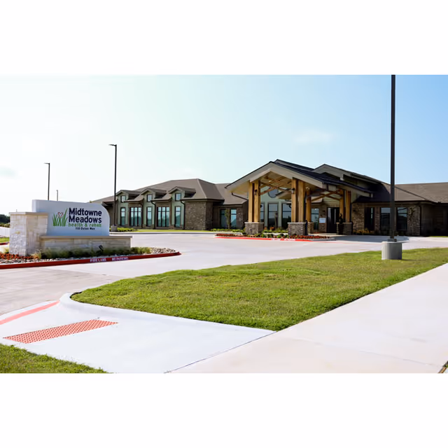The Midtowne Meadows building exterior with a covered entrance and manicured lawn.