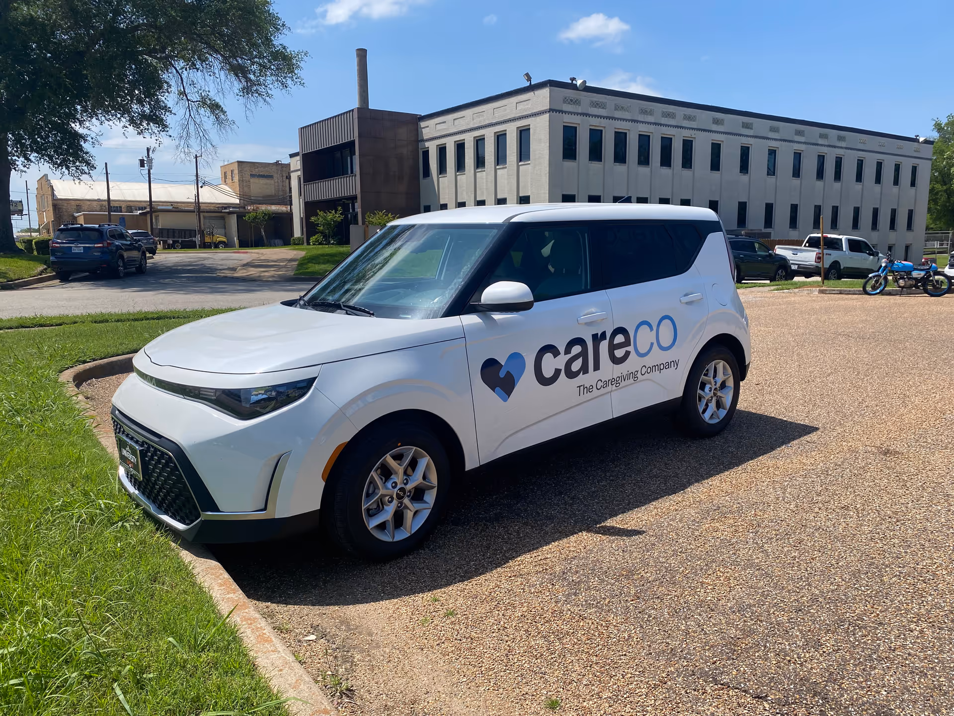 White CareCo vehicle parked in front of a large facility exterior