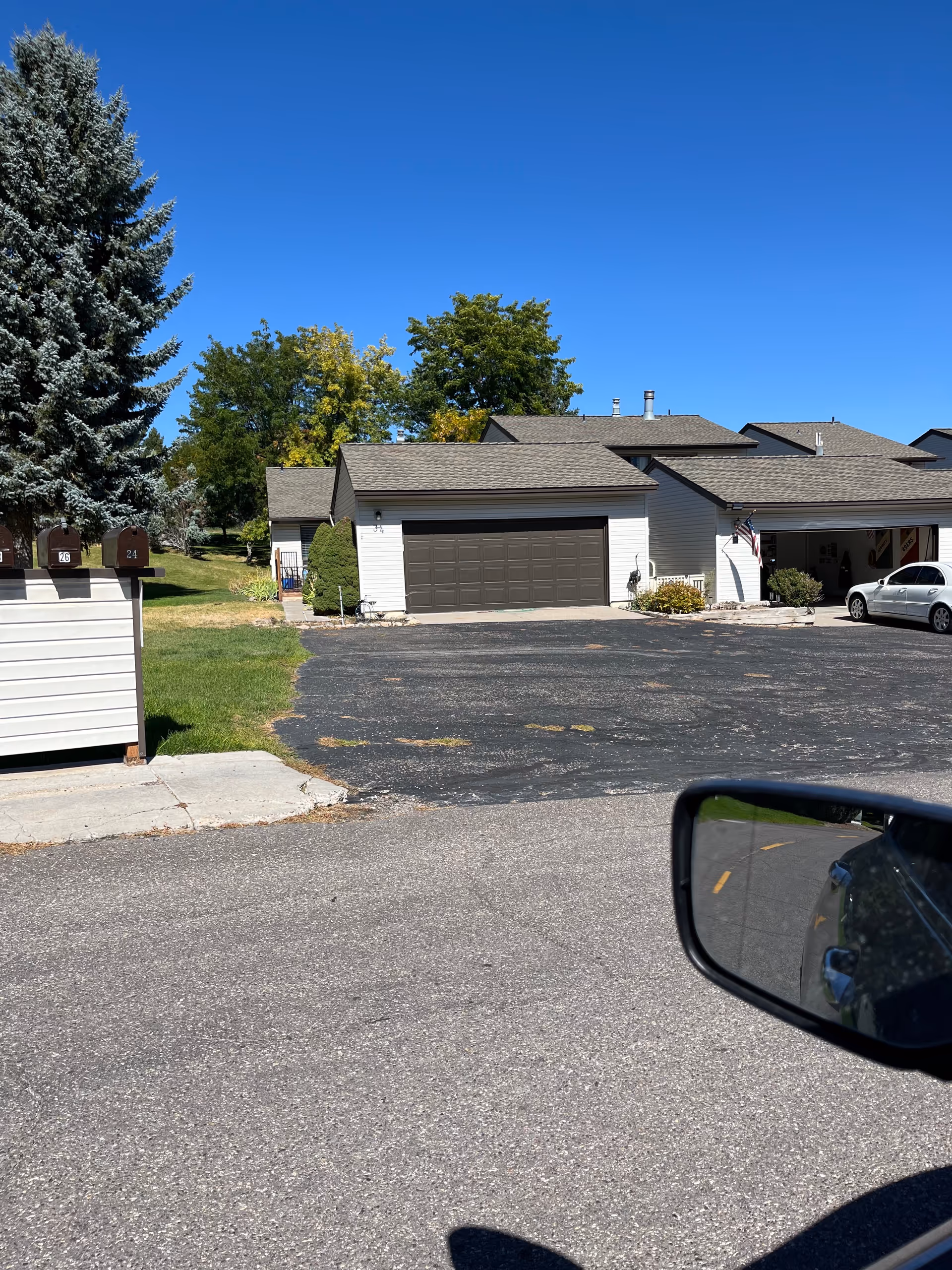 Exterior view of a senior living facility with garages and an adjacent driveway.