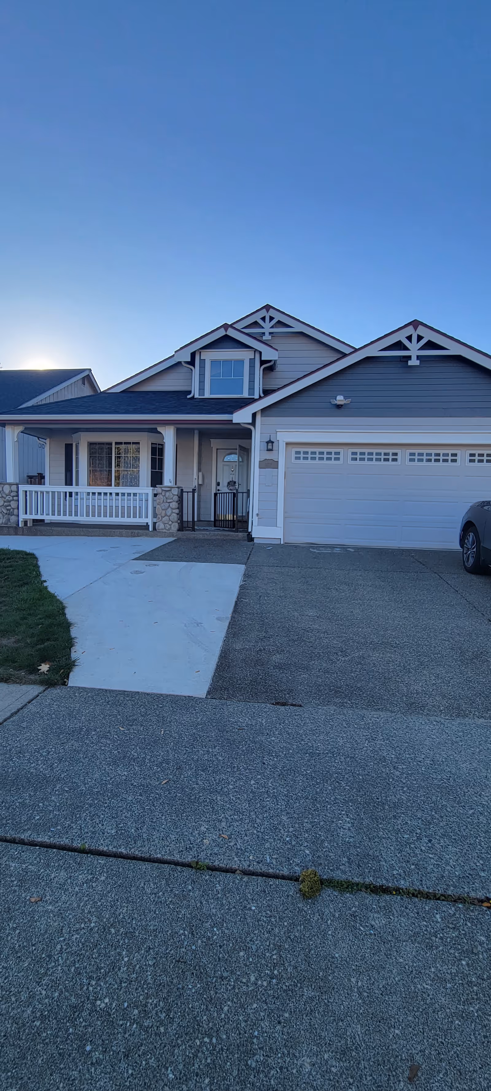 Front view of a two-car garage home with a porch and driveway.