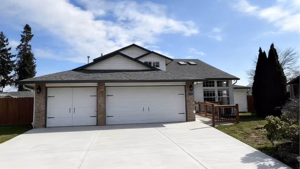 Front exterior of a suburban home featuring a two-car garage, ramp to entry, and driveway.