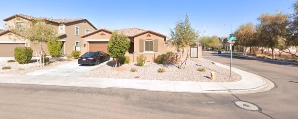 Exterior view of Liberty Assisted Living Home LLC building with a circular driveway and desert landscaping.