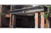 The brick building entrance features a covered portico and brick columns.
