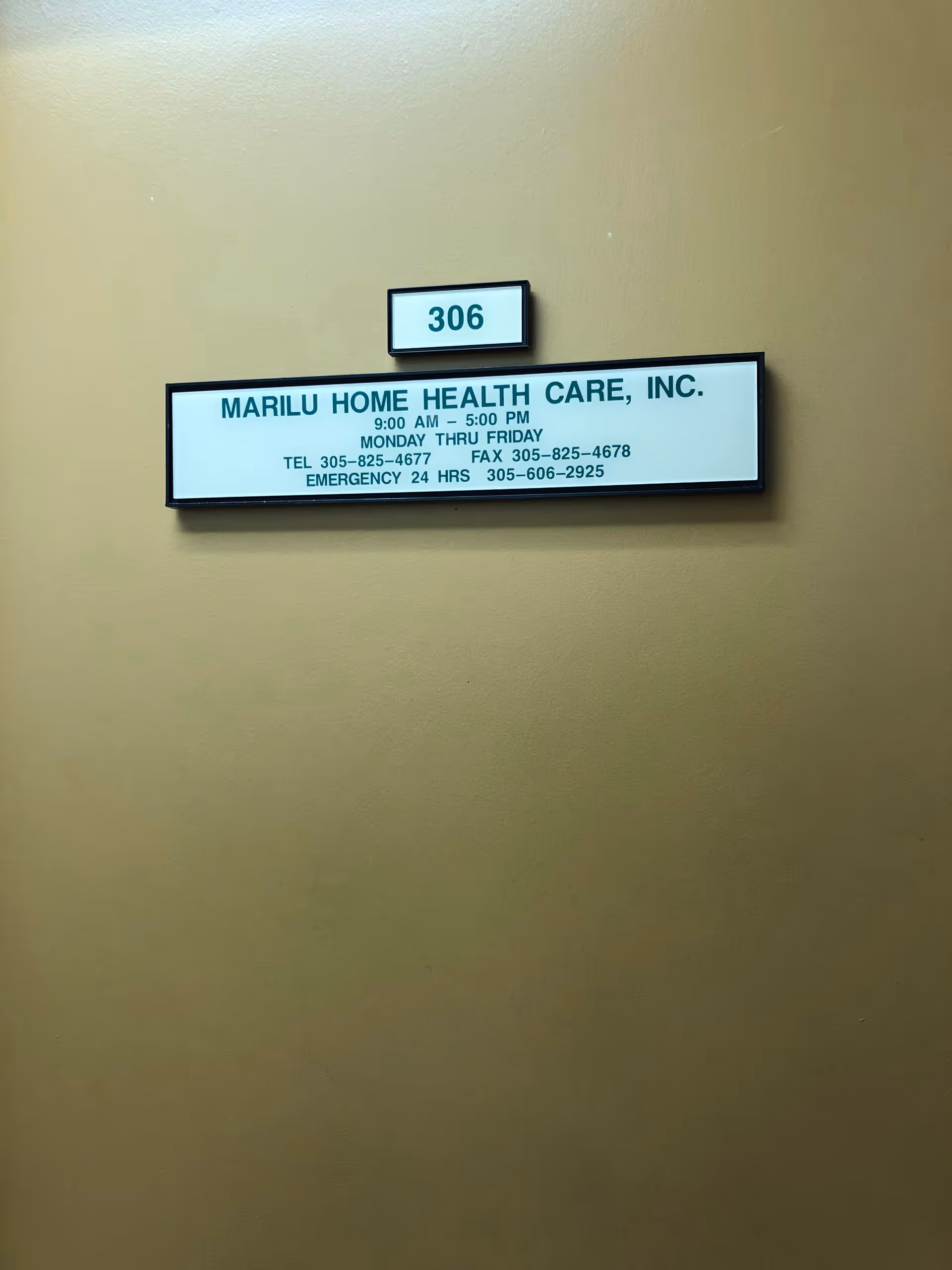 Sign on beige hallway wall displays Marilu Home Health Care, Inc. and room 306.