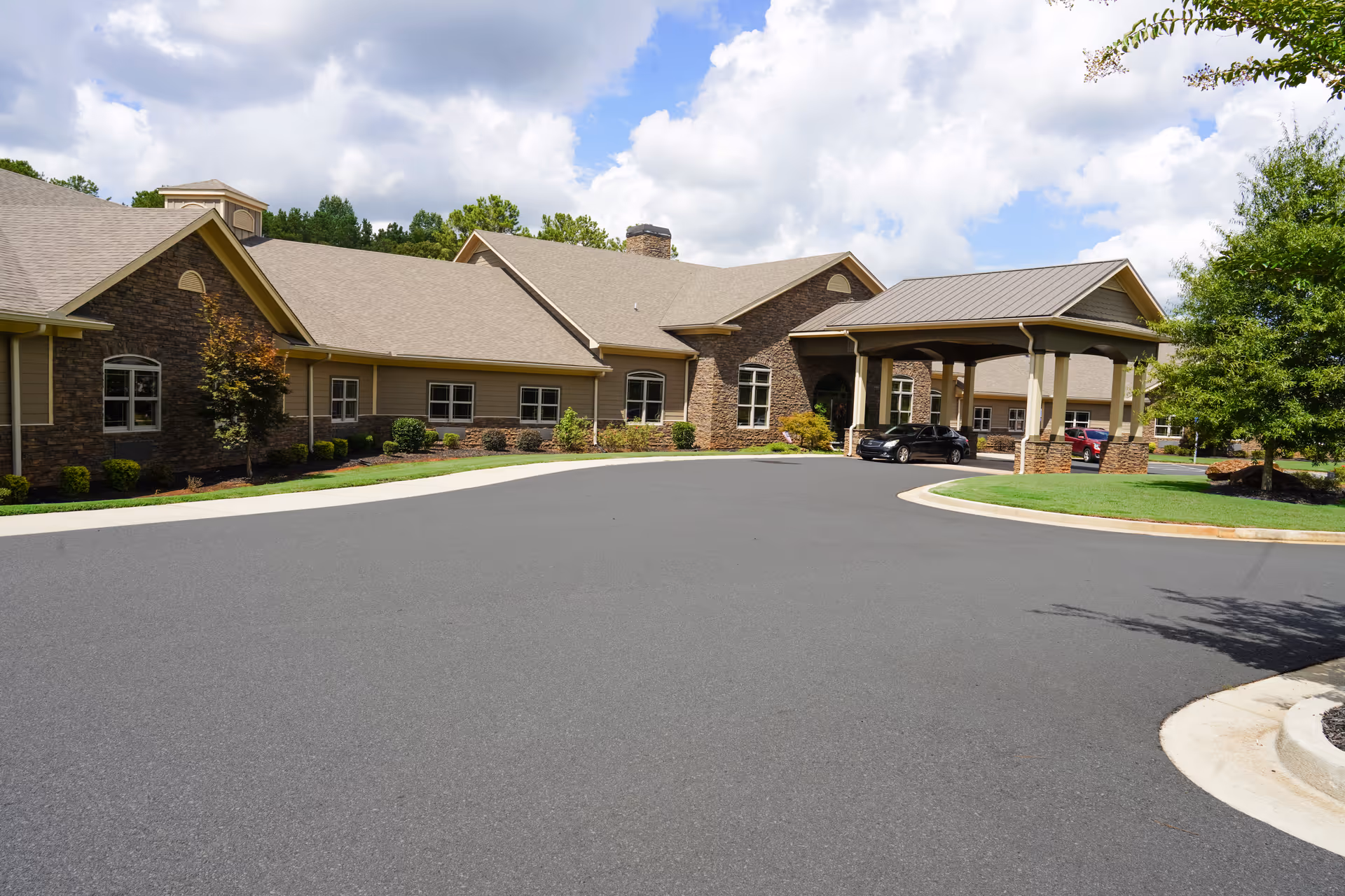 A single-story senior living facility exterior with a covered entrance and circular driveway.
