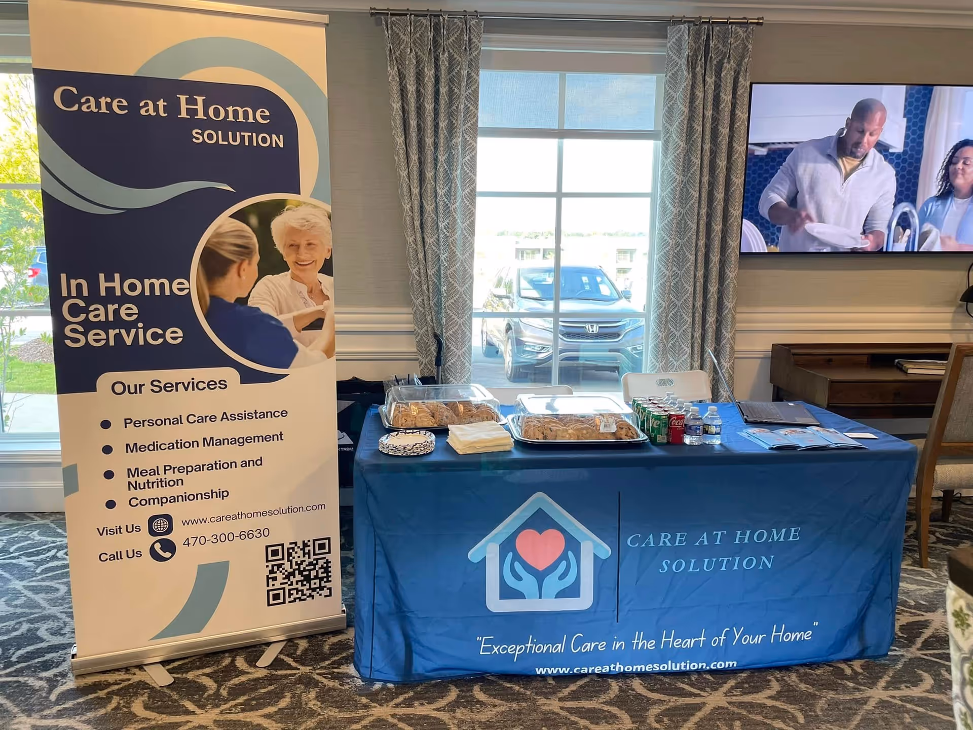 Promotional display for Care at Home Solution with banner and information table indoors.