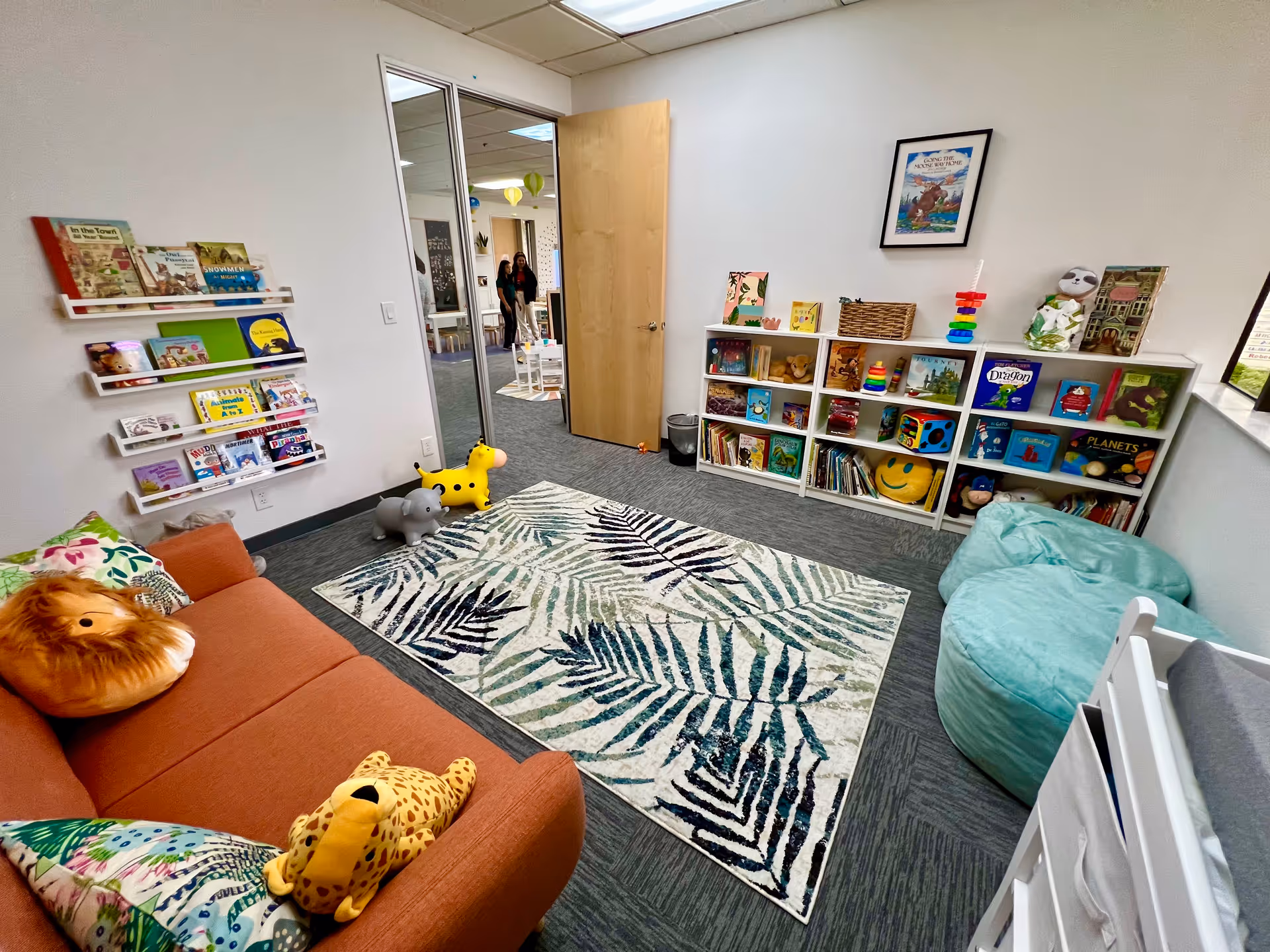 Joyscape Therapy playroom with bookshelves, toys, sofa, beanbags, and a patterned rug.
