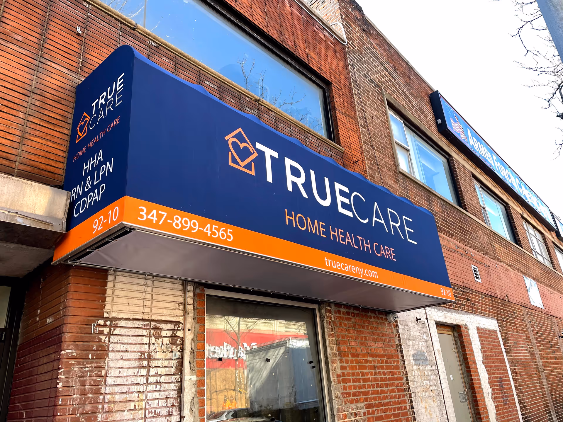 Blue TrueCare sign on brick building exterior advertising home health care services