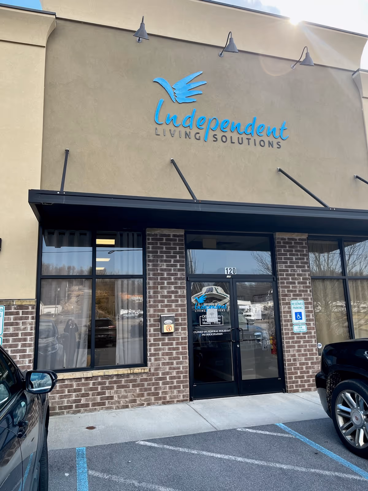 Front exterior of Independent Living Solutions facility featuring a blue logo sign on brick facade