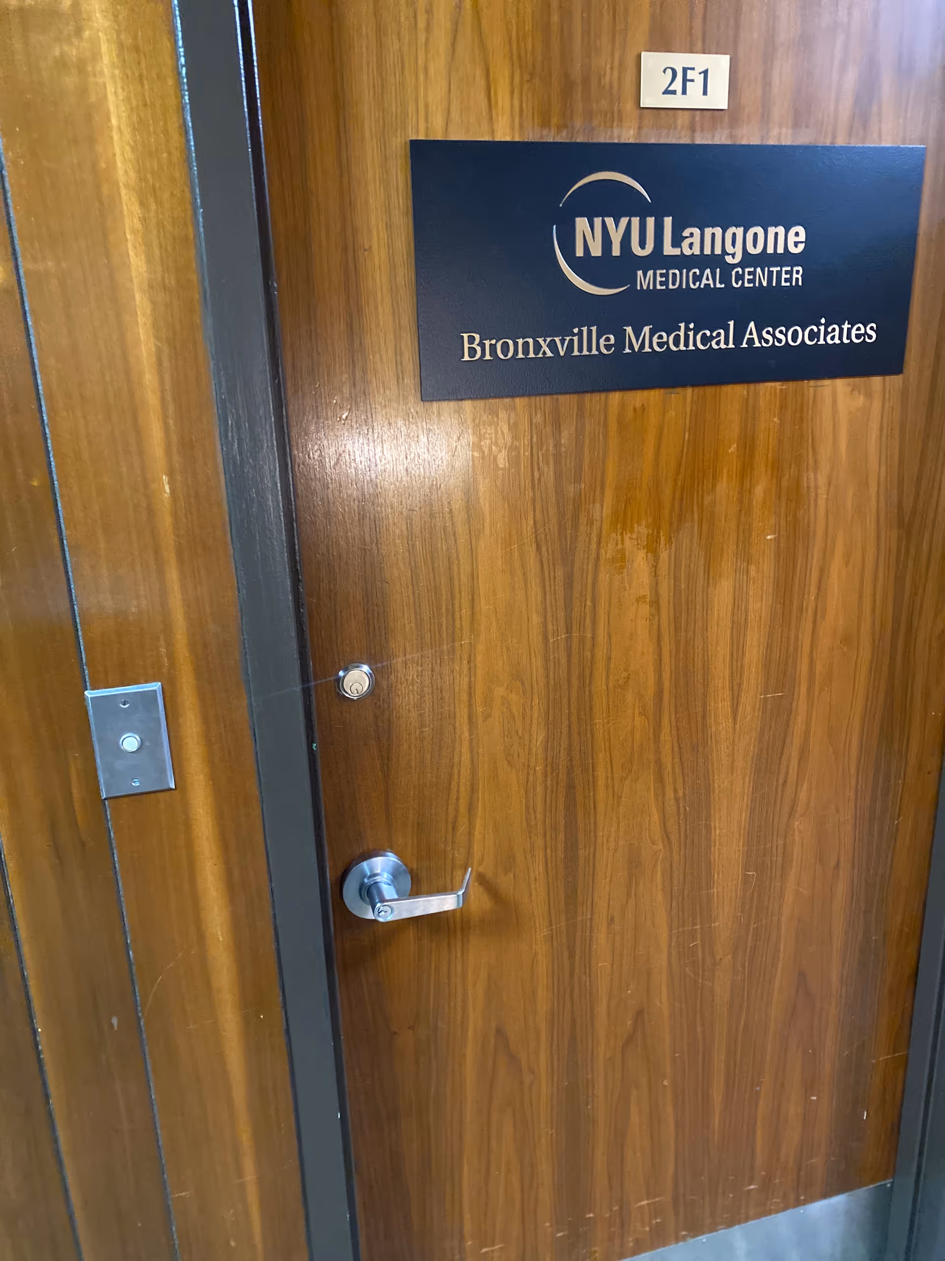 Wooden interior door with NYU Langone Medical Associates Bronxville plaque.