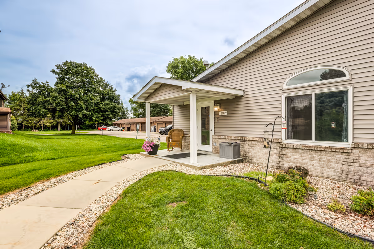 Front exterior view of Dimensions Living Beloit with a walkway and entrance canopy.