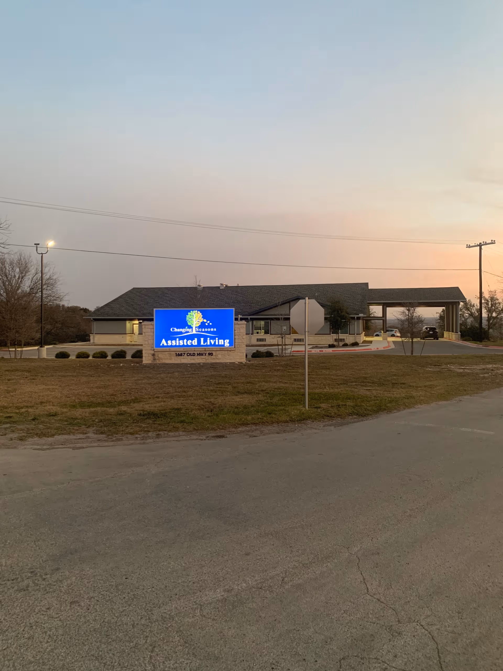 Exterior view of Changing Seasons Assisted Living with blue sign and accessible entrance.