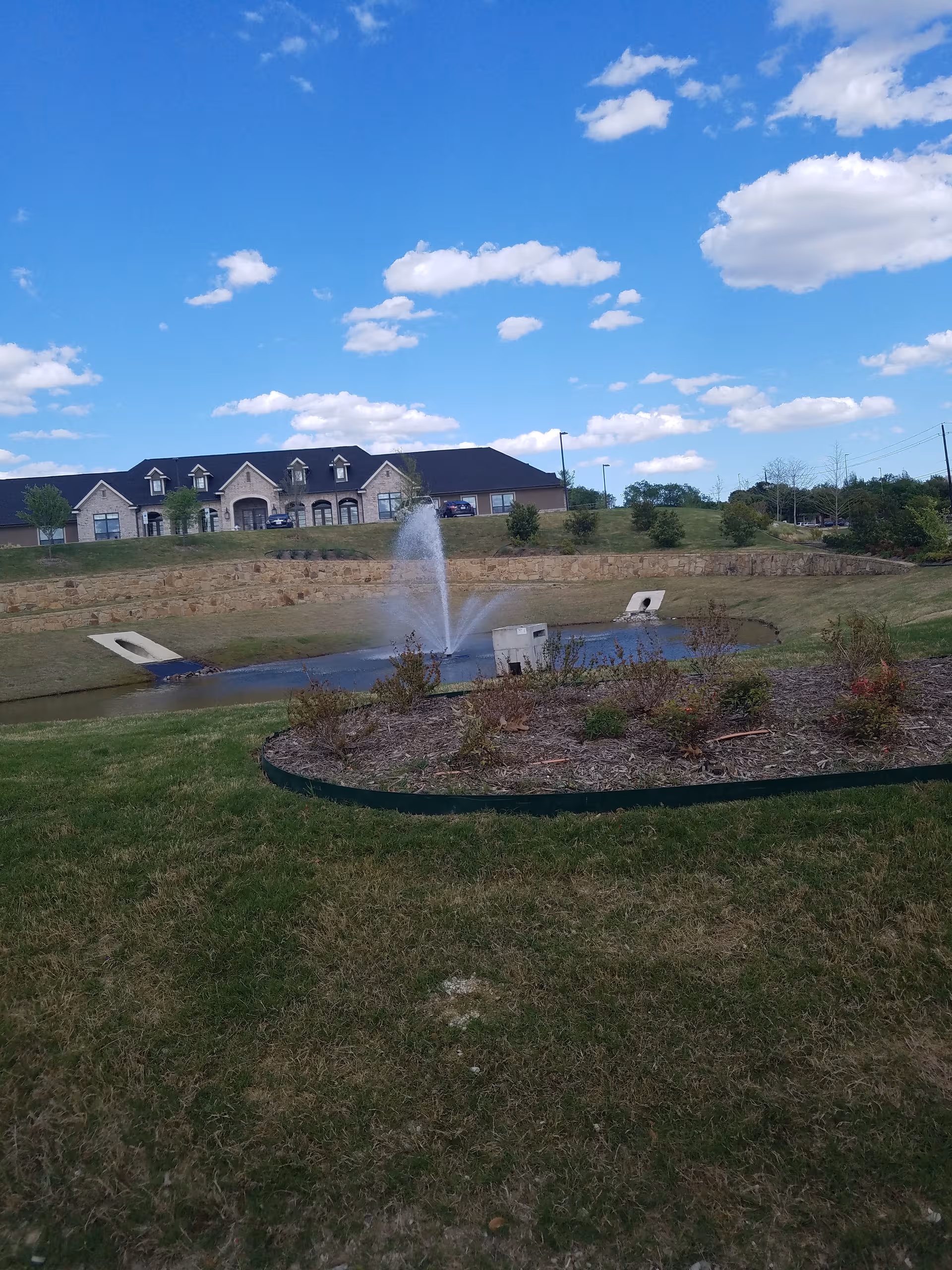 Front view of Briarview Senior Living with a fountain pond and landscaped grounds.