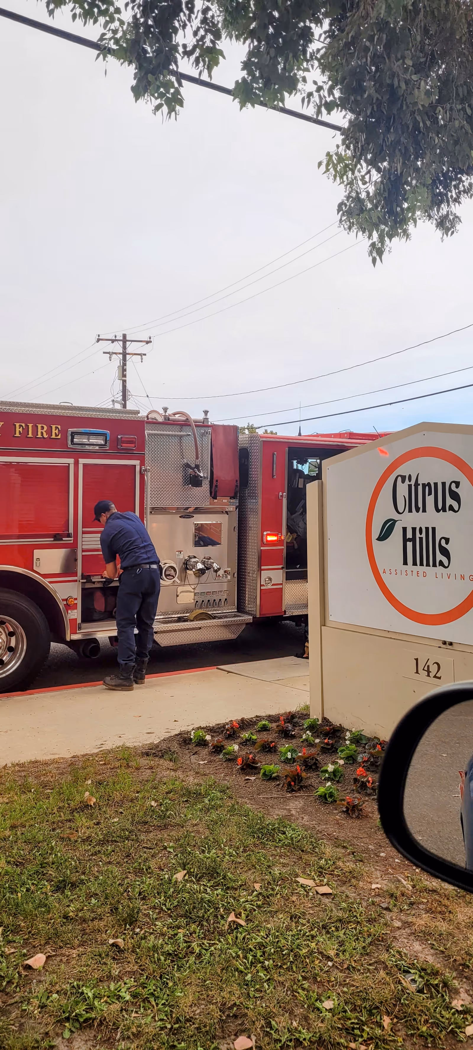 Fire truck outside Citrus Hills Assisted Living with a worker near the vehicle.