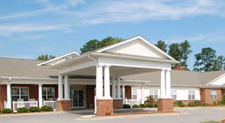 Front view of Lily Homes Inc facility with a covered entrance and brick columns.