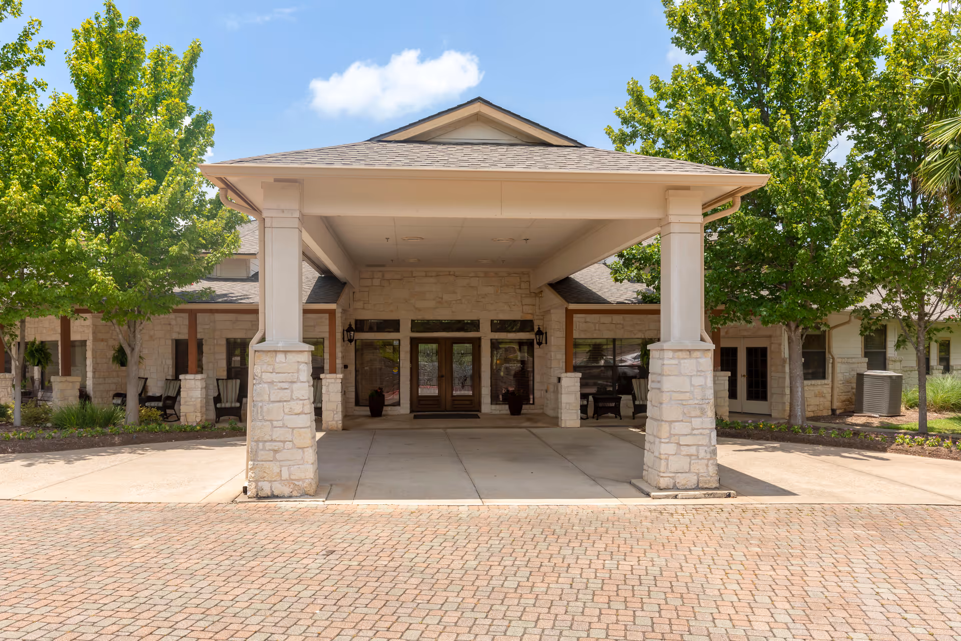 Entrance to Brookdale Lohmans Crossing with a covered porte-cochère and stone columns.