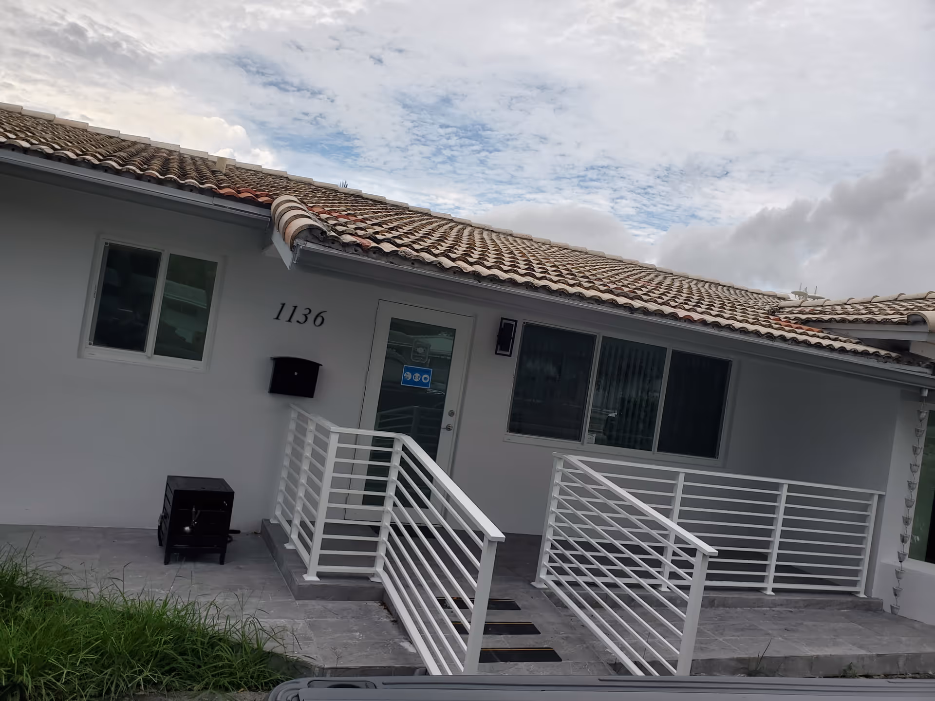 Exterior view of a senior care facility entrance with ramp and white railing