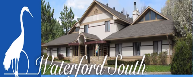 Exterior front view of Waterford South senior living building with blue banner featuring a white heron.