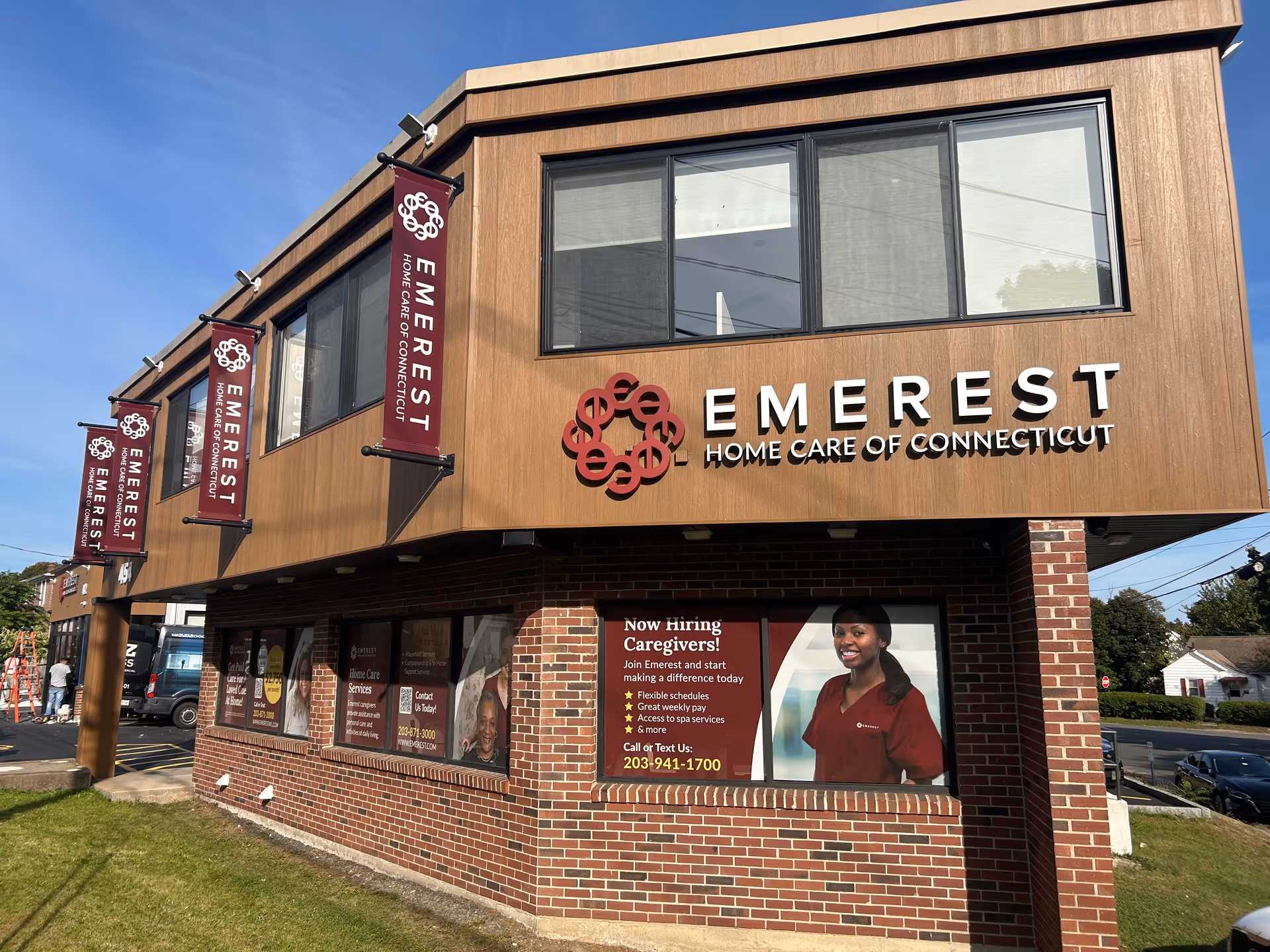 Exterior view of Emerest Home Care of Connecticut building with large sign and banners.