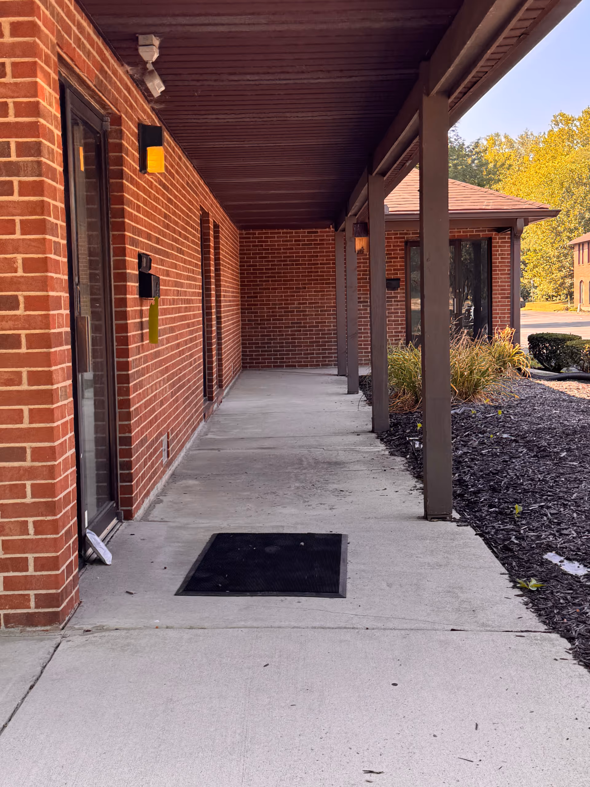 Exterior view of a brick senior living facility with a covered walkway.
