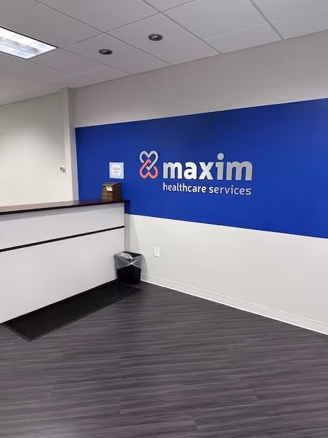Maxim Healthcare Columbus office reception area with blue logo wall.