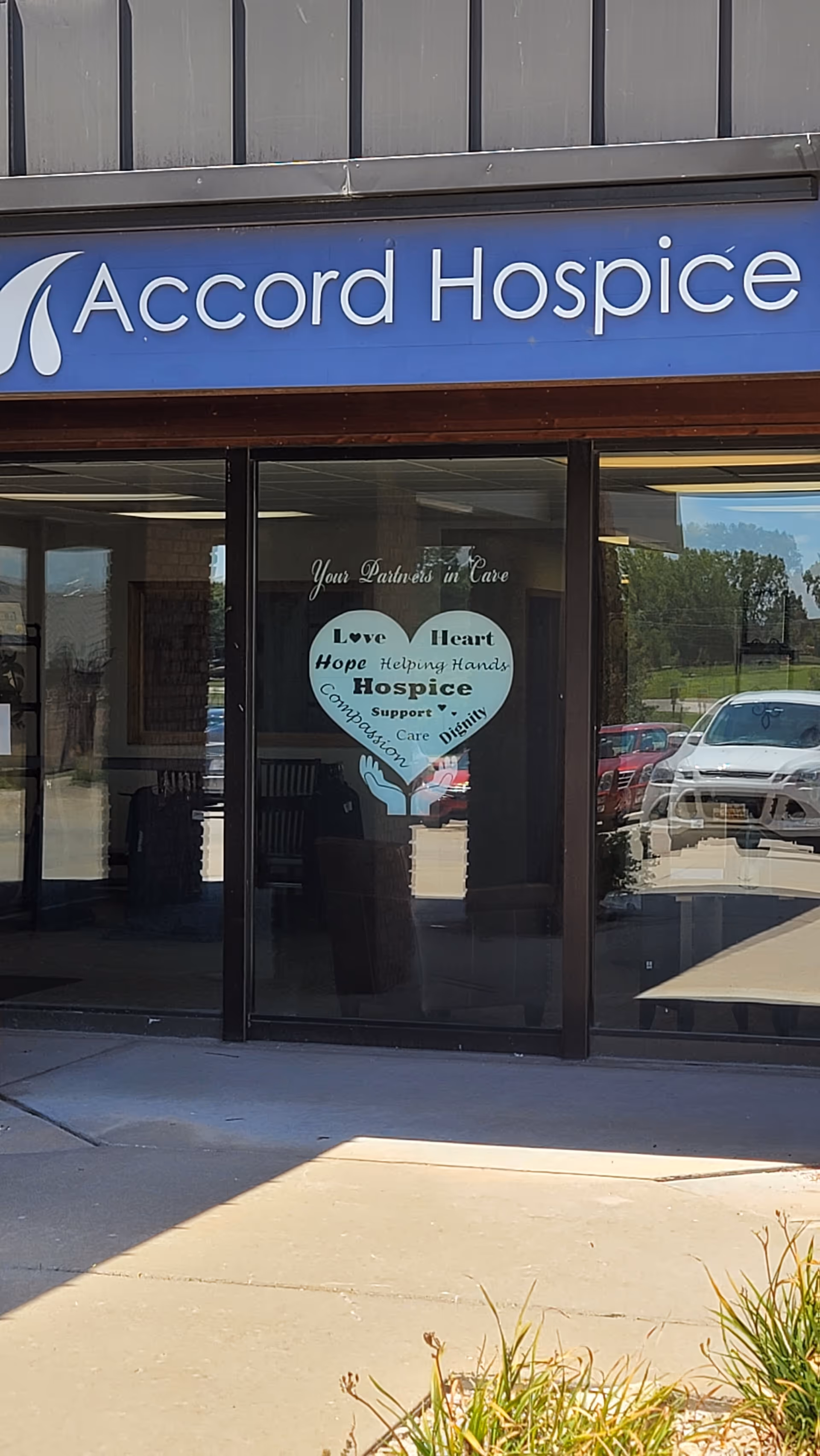 Blue Accord Hospice storefront with glass doors and a heart-shaped window decal.