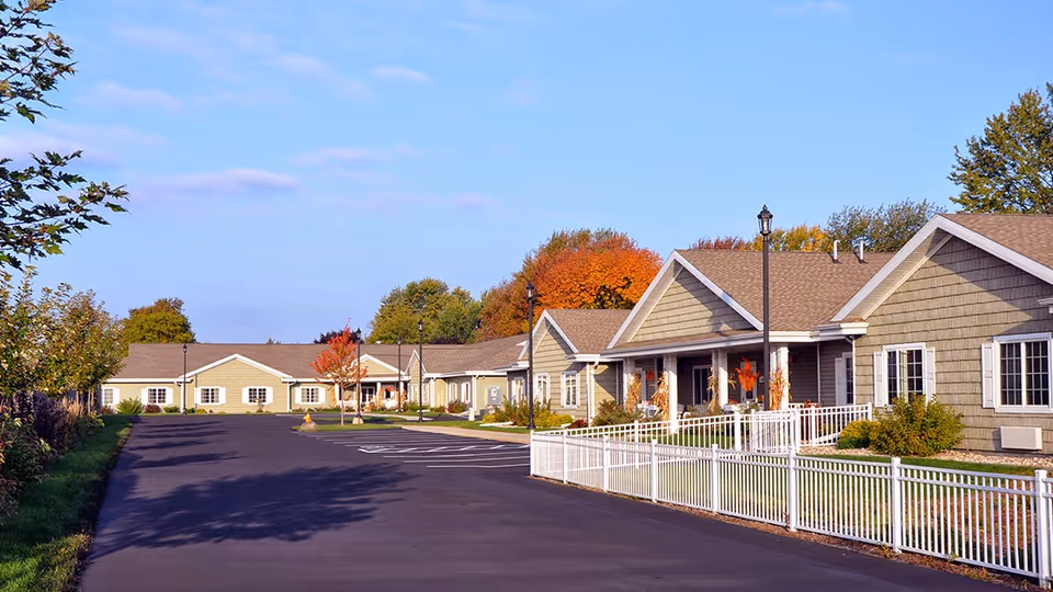 Heartwood Senior Living campus features single-story beige cottages along a curved driveway.