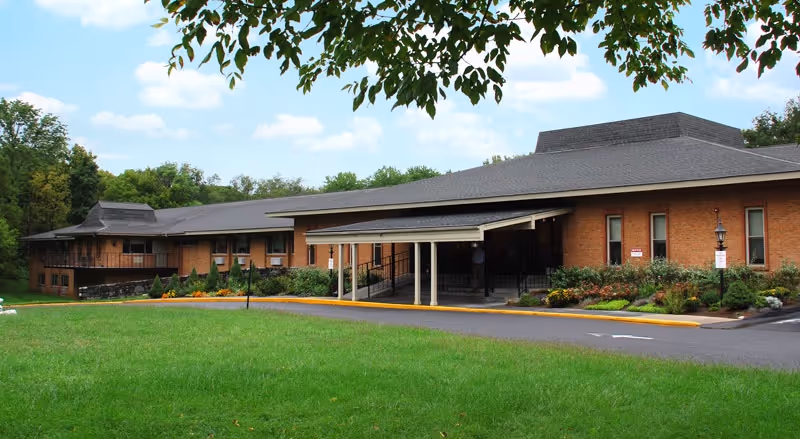 Exterior view of Evergreen Health and Rehab building with lawn and driveway.