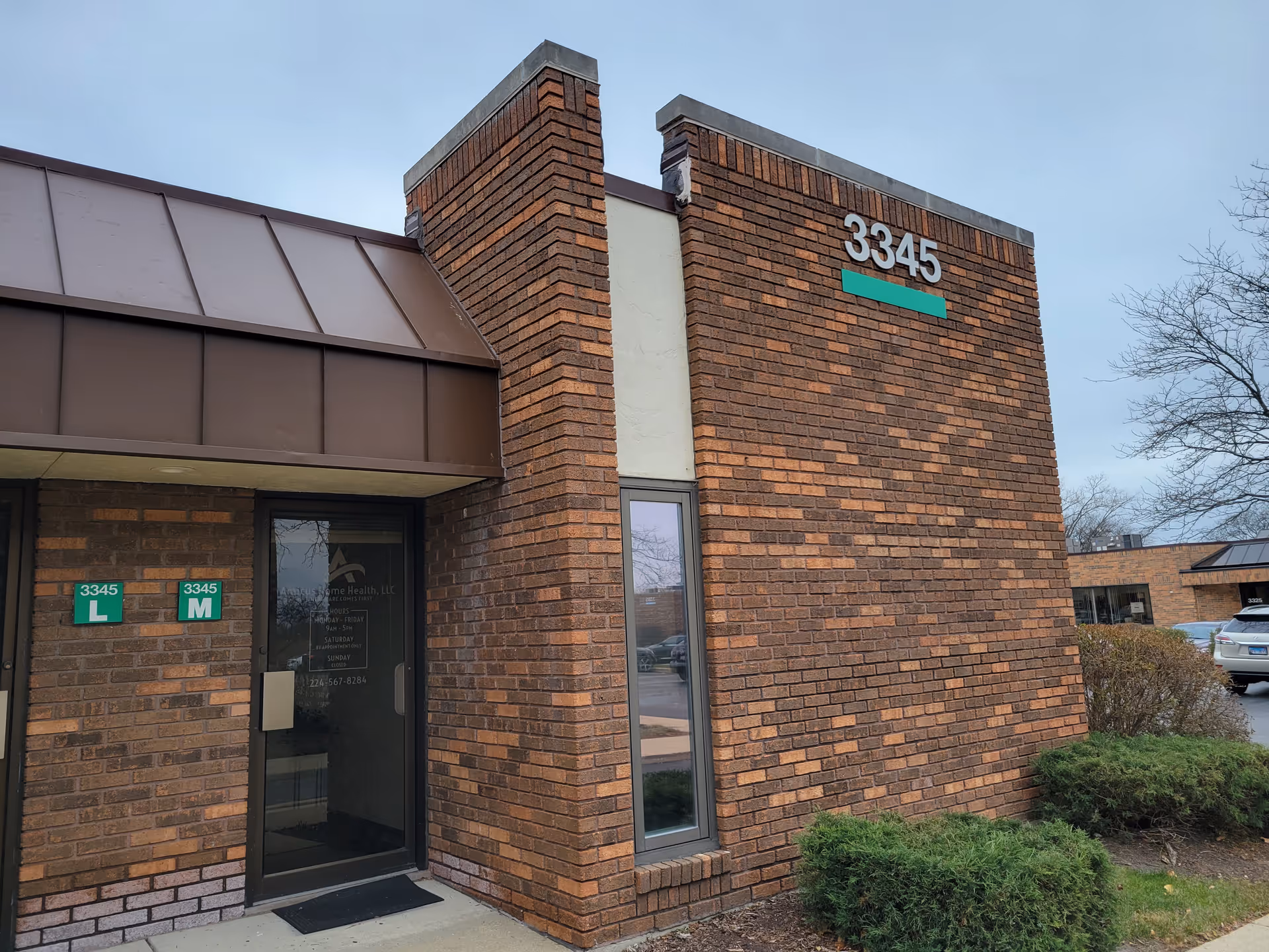 Brick building front with large address 3345 and glass entrance door.