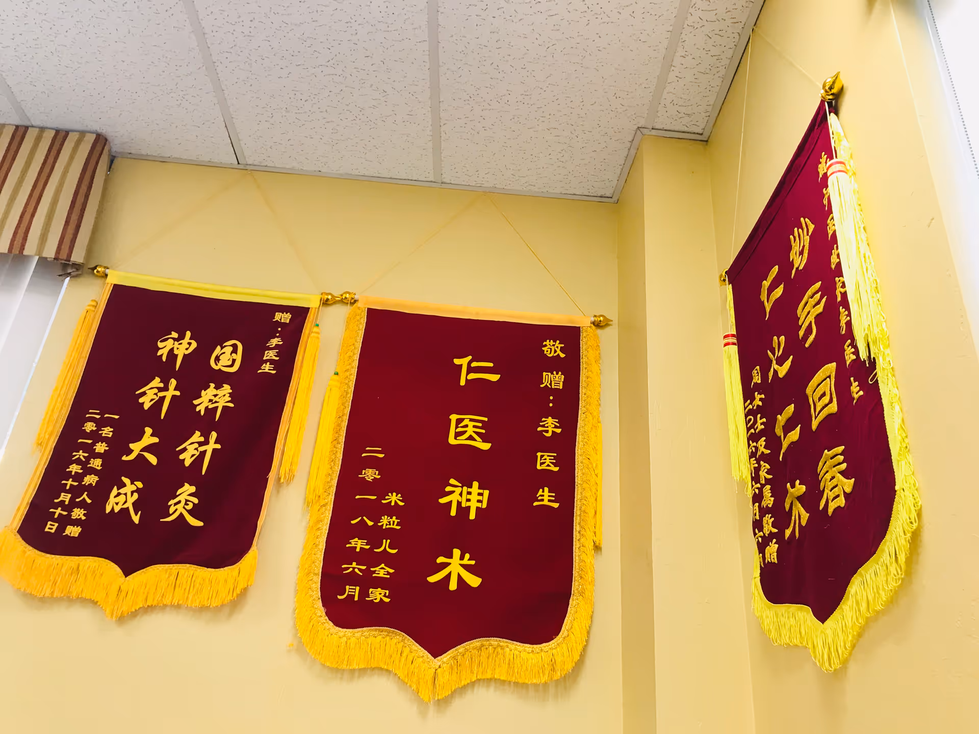 Interior of a facility hallway with maroon banners featuring gold Chinese text.