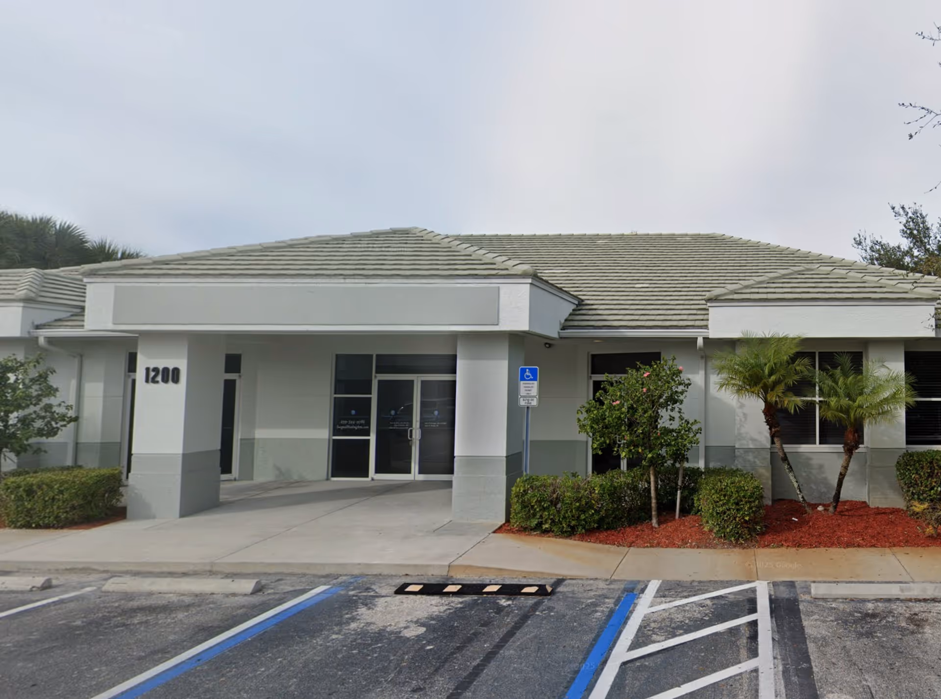 Gray, single-story facility with a covered entrance and handicap parking spaces.