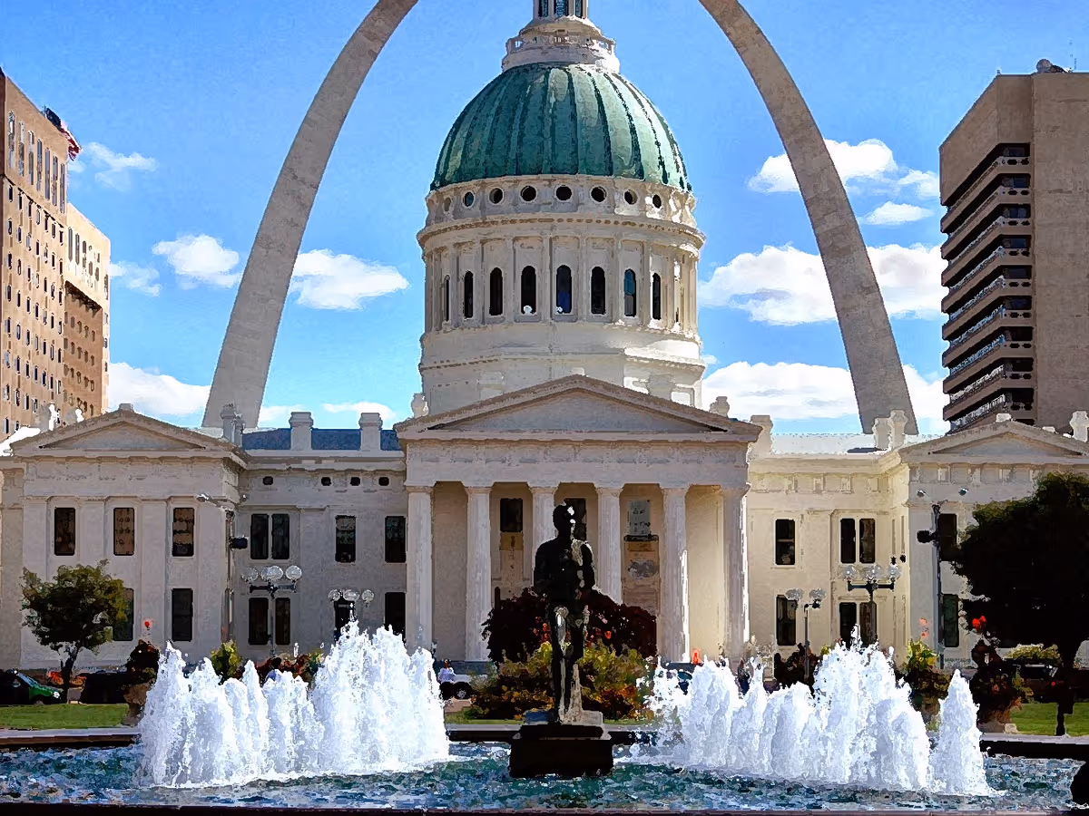 Outdoor view of a domed neoclassical building with a statue and fountains.