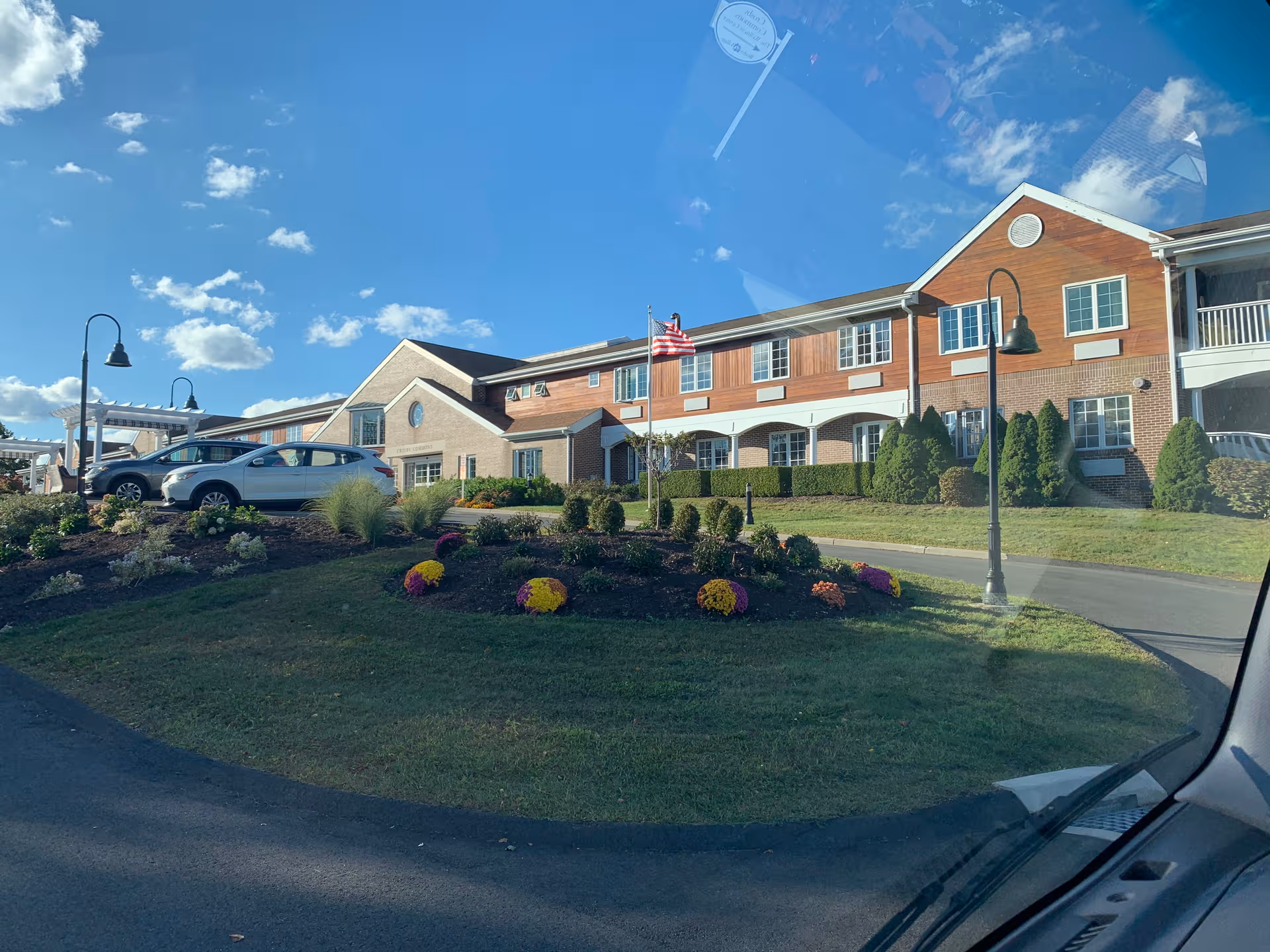 Exterior view of Masonicare at Crosby Commons, brick senior living building with landscaped grounds.