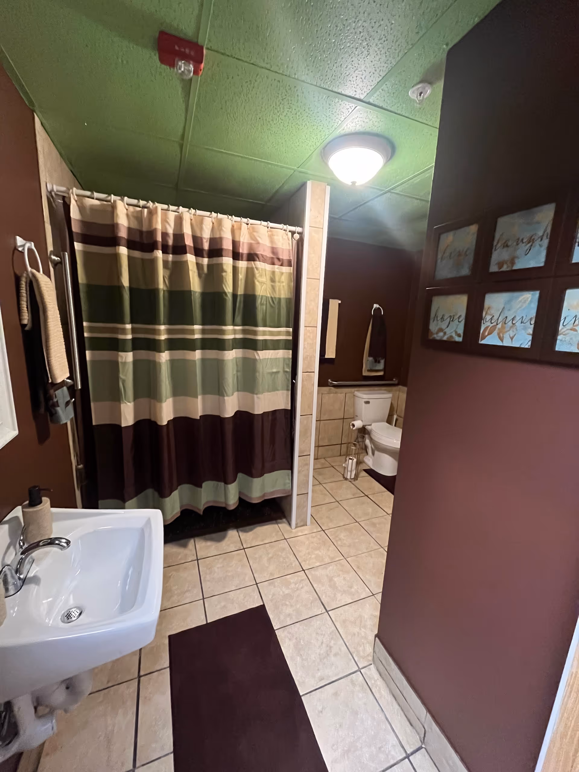 Small bathroom with sink, toilet, and striped shower curtain.