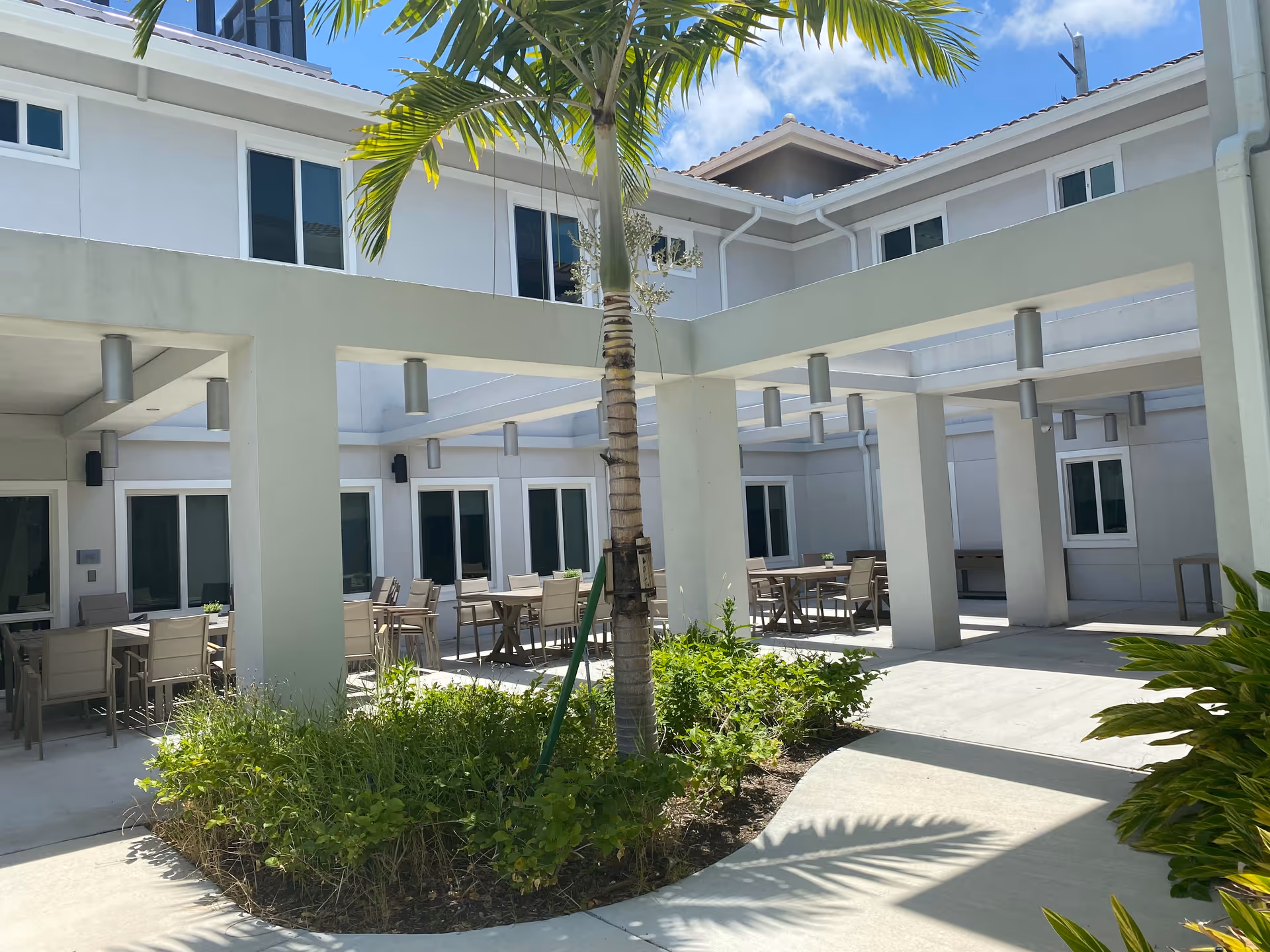 Outdoor courtyard with seating under covered walkways at The Lilac at Silver Palms.