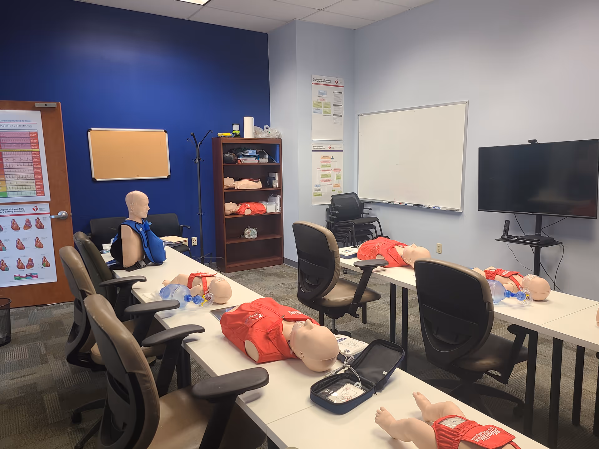 Training room with CPR mannequins and medical equipment on tables