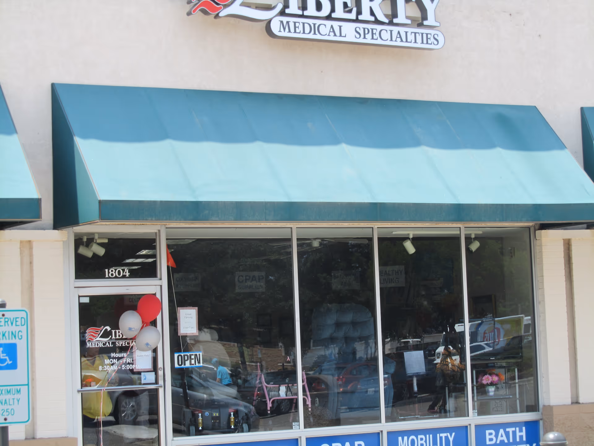 Exterior storefront with teal awnings and large glass windows for Liberty Medical Specialties.