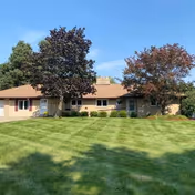 Front view of Sugarbush Living Calkins House, a single-story building with a green lawn.