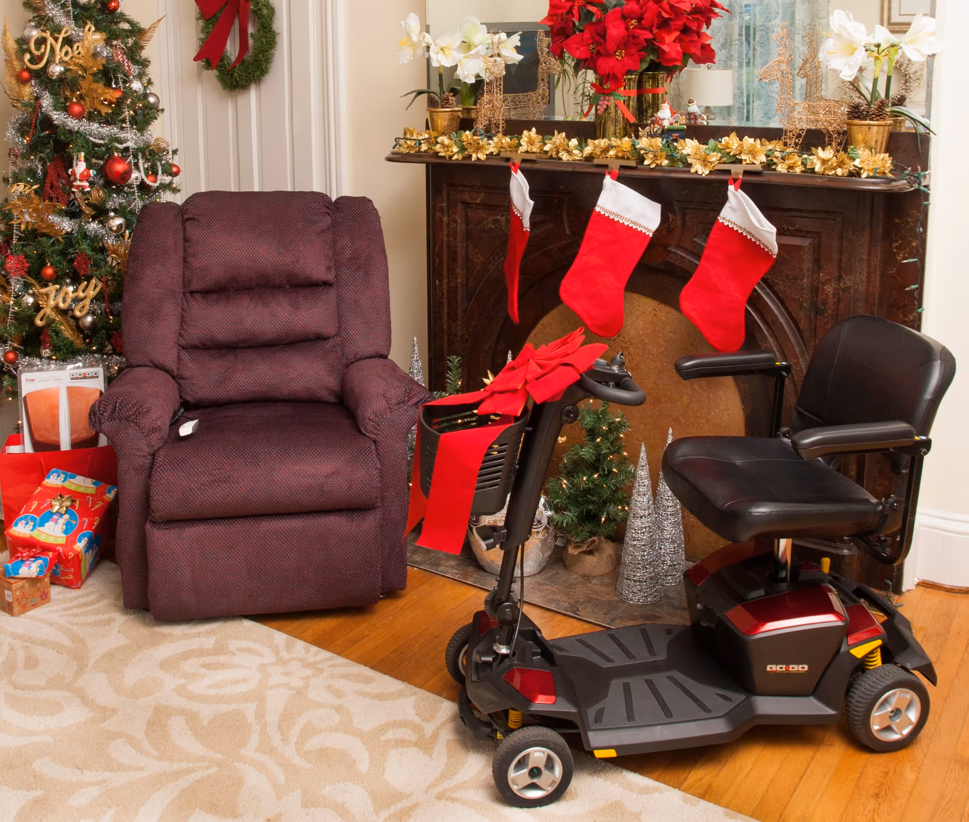 A festively decorated living room with a recliner, mobility scooter, stockings, and Christmas tree.