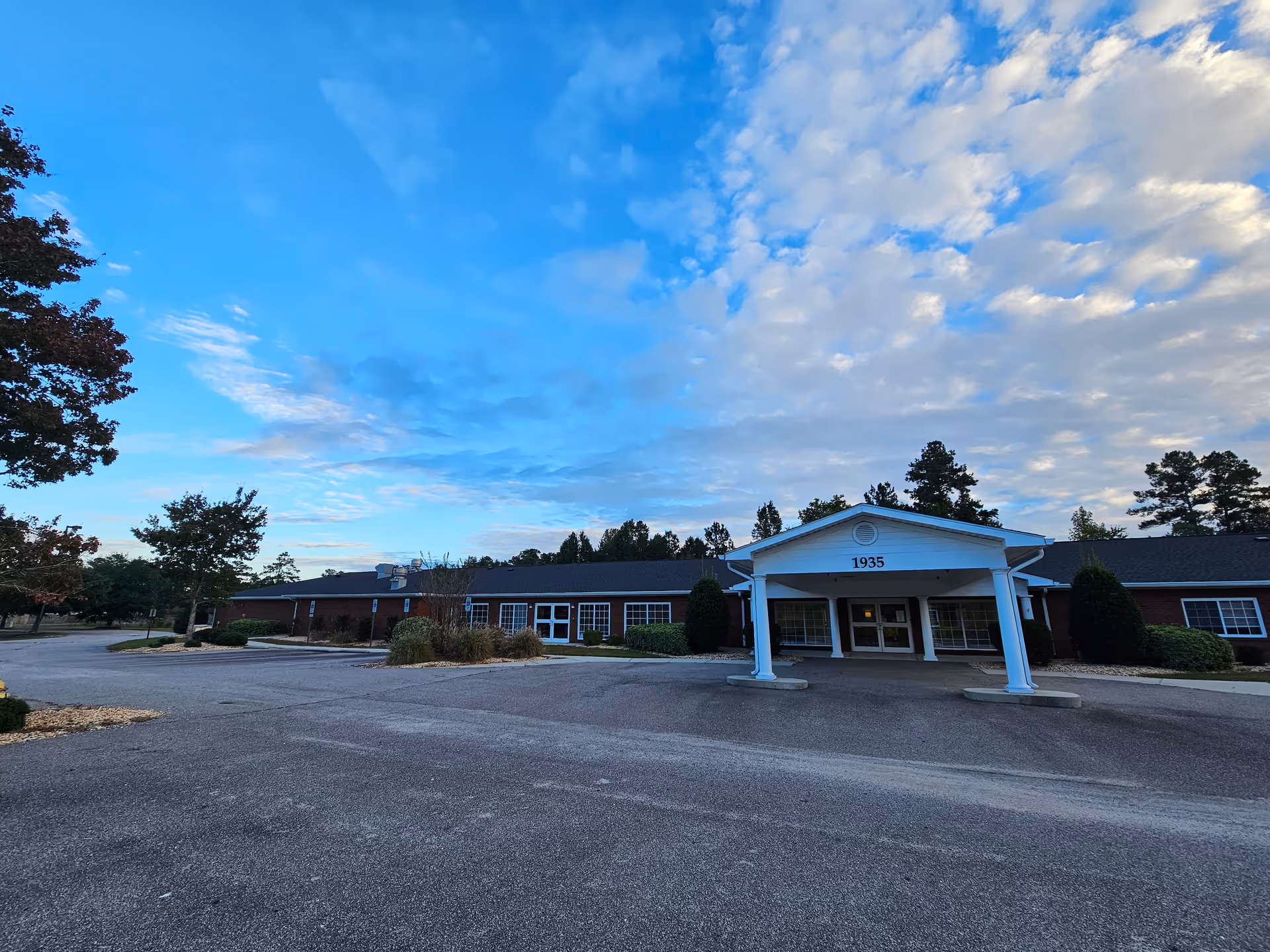 Exterior view of Leland House senior living facility with a covered front entrance.
