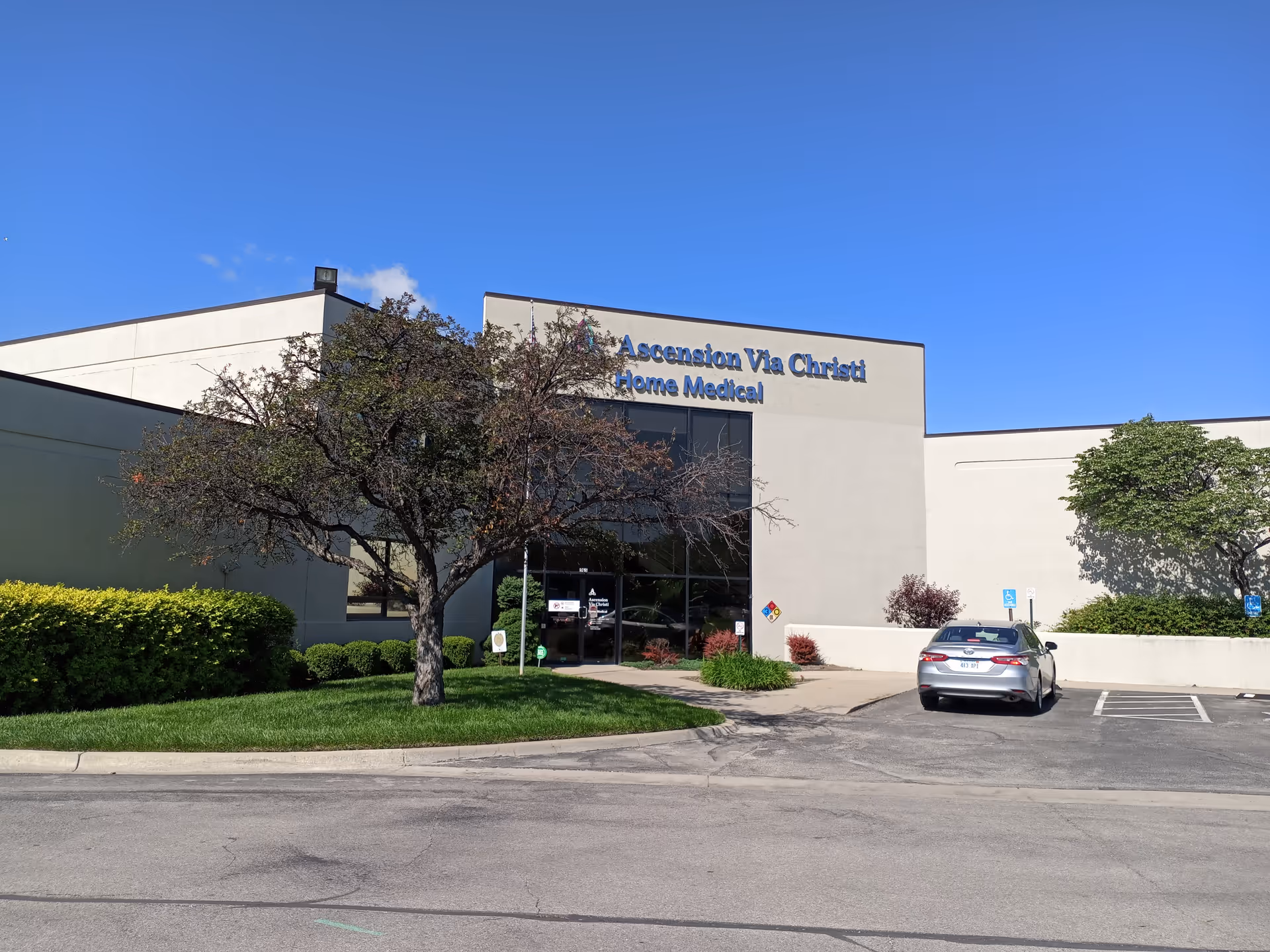 Exterior of Ascension Via Christi Home Medical building with parking lot and trees