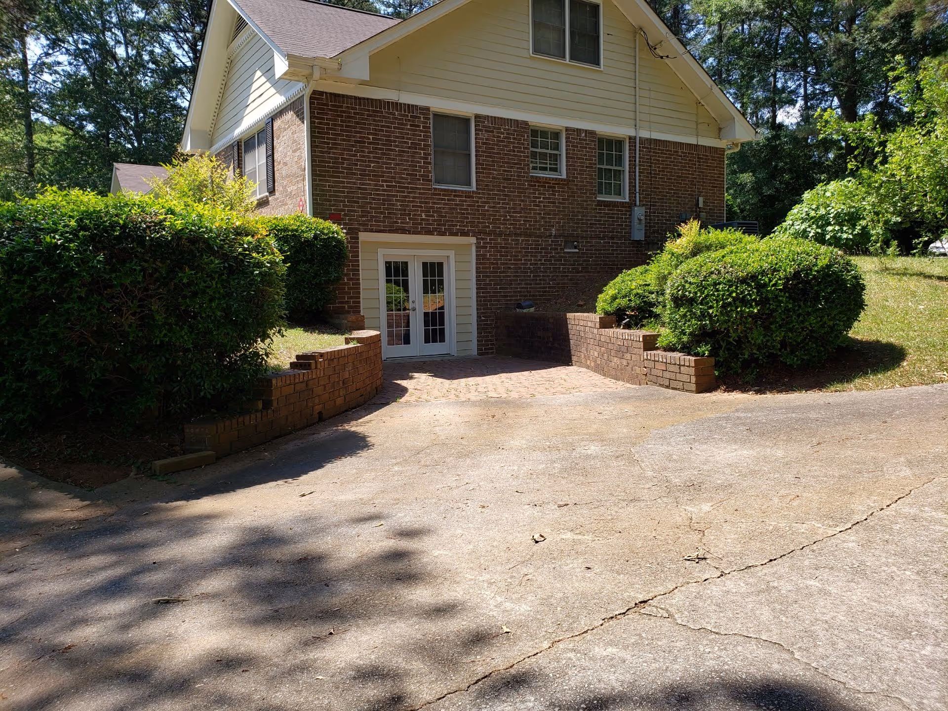 Brick two-story building with double doors and landscaped entry.