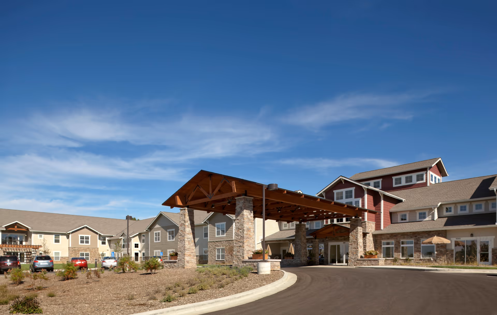 Exterior view of Westchester Village of Lenexa showing the covered entrance and parked cars.