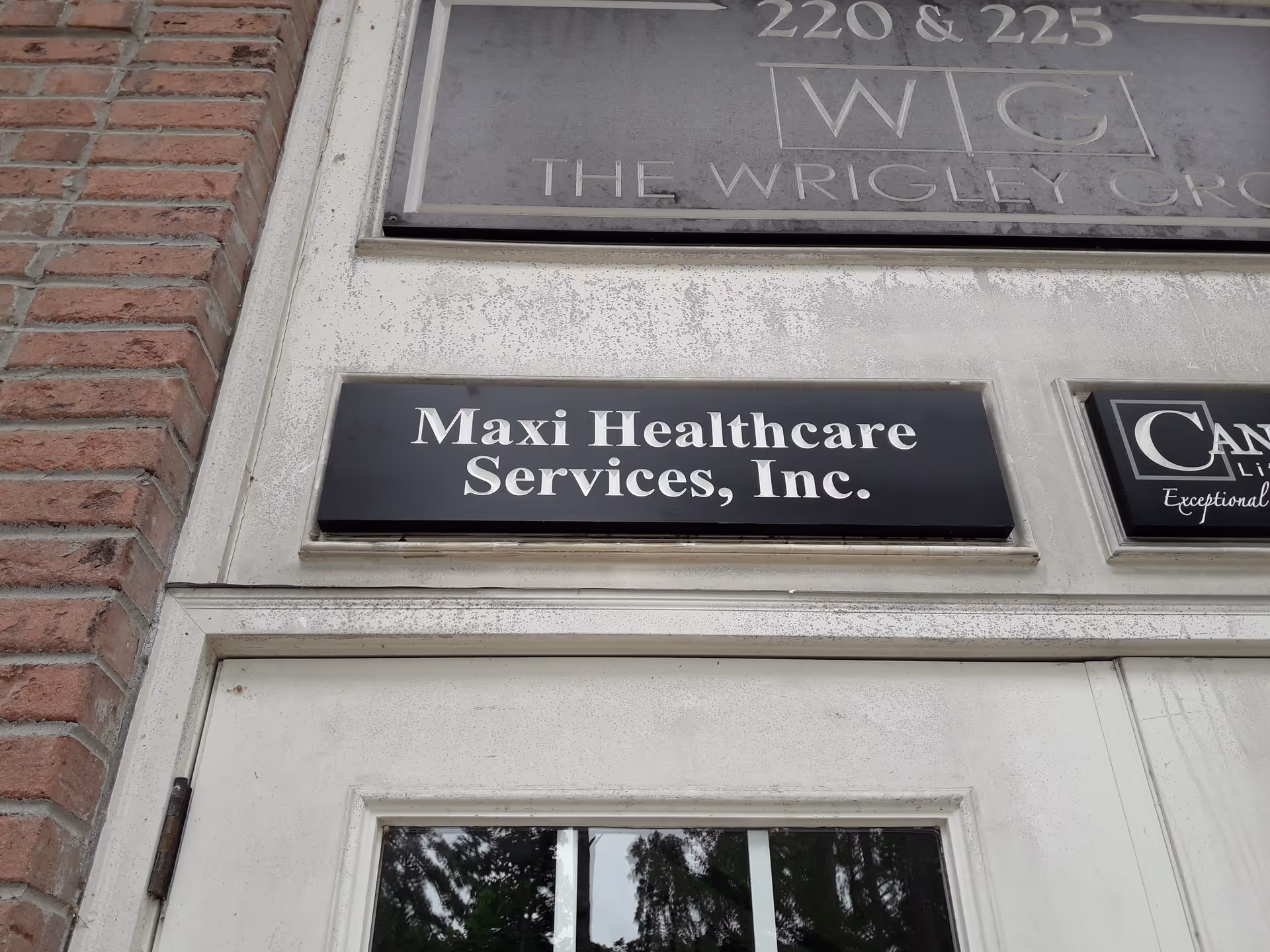 Exterior sign for Maxi Healthcare Services, Inc. on a brick building facade