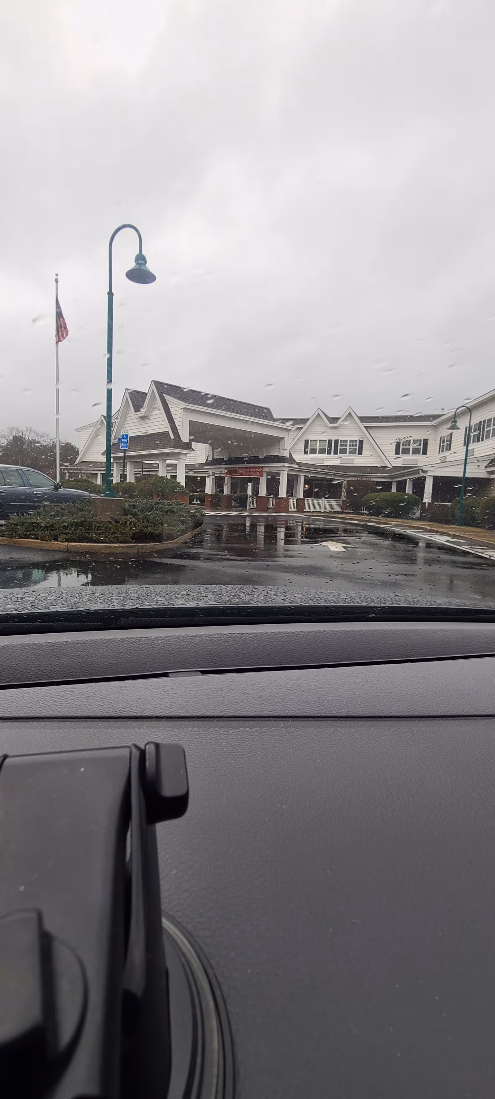 Front view of Brightview Concord River senior living facility on a rainy day.