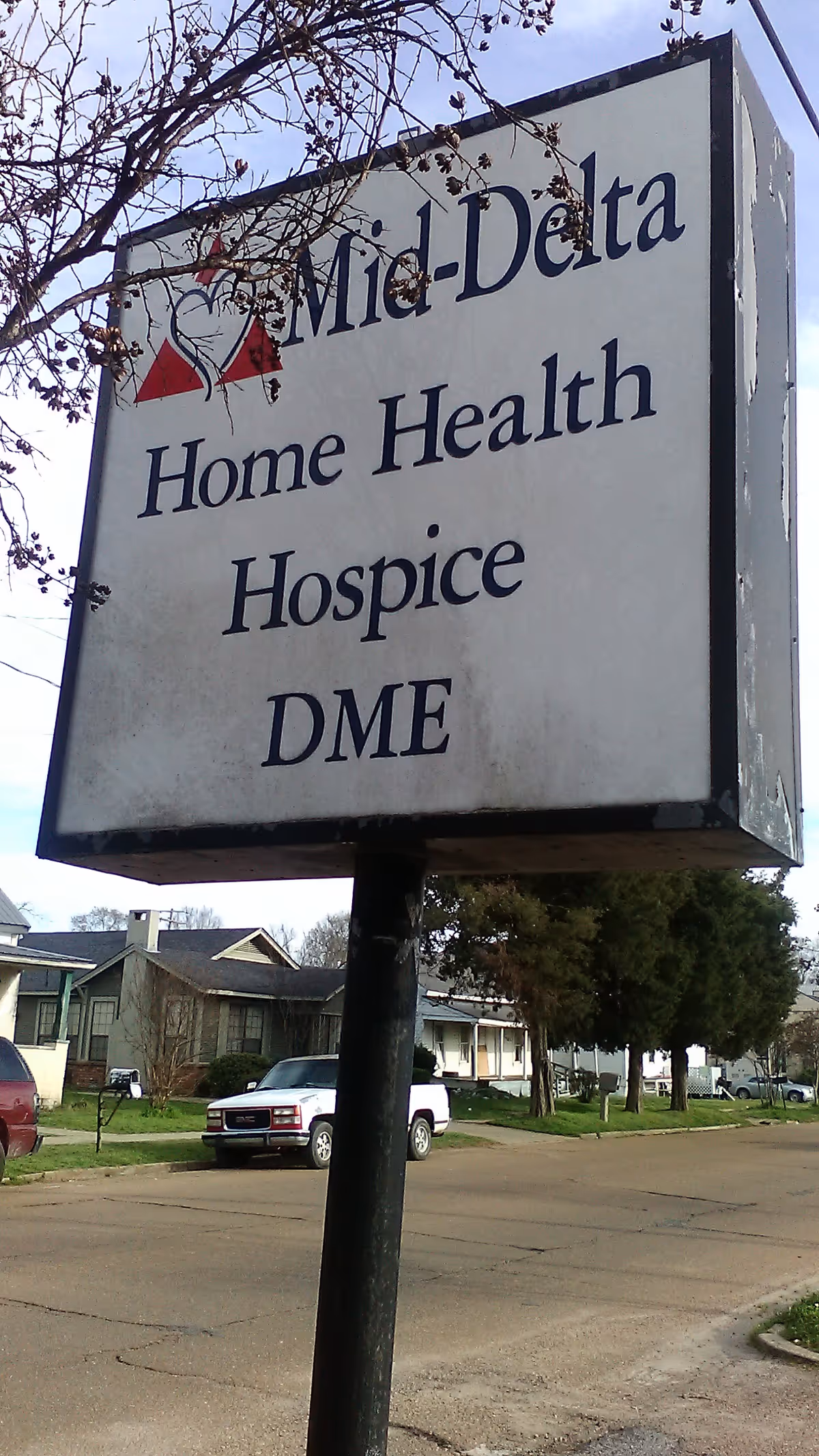 An outdoor sign for Mid-Delta Home Health Hospice DME beside a street.
