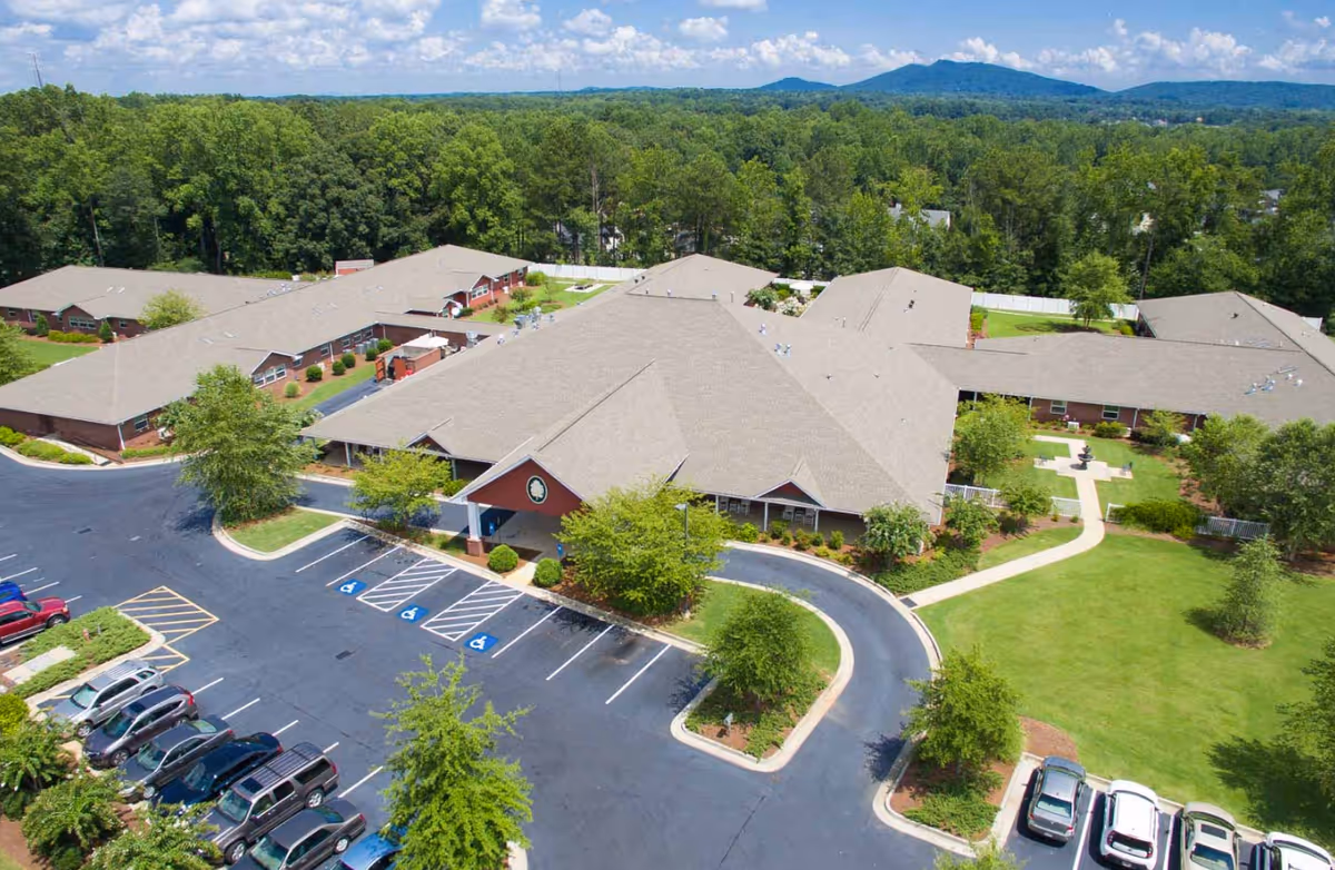 Aerial view of Oaks at Post Road exterior, showing buildings, parking lot, and green grounds.